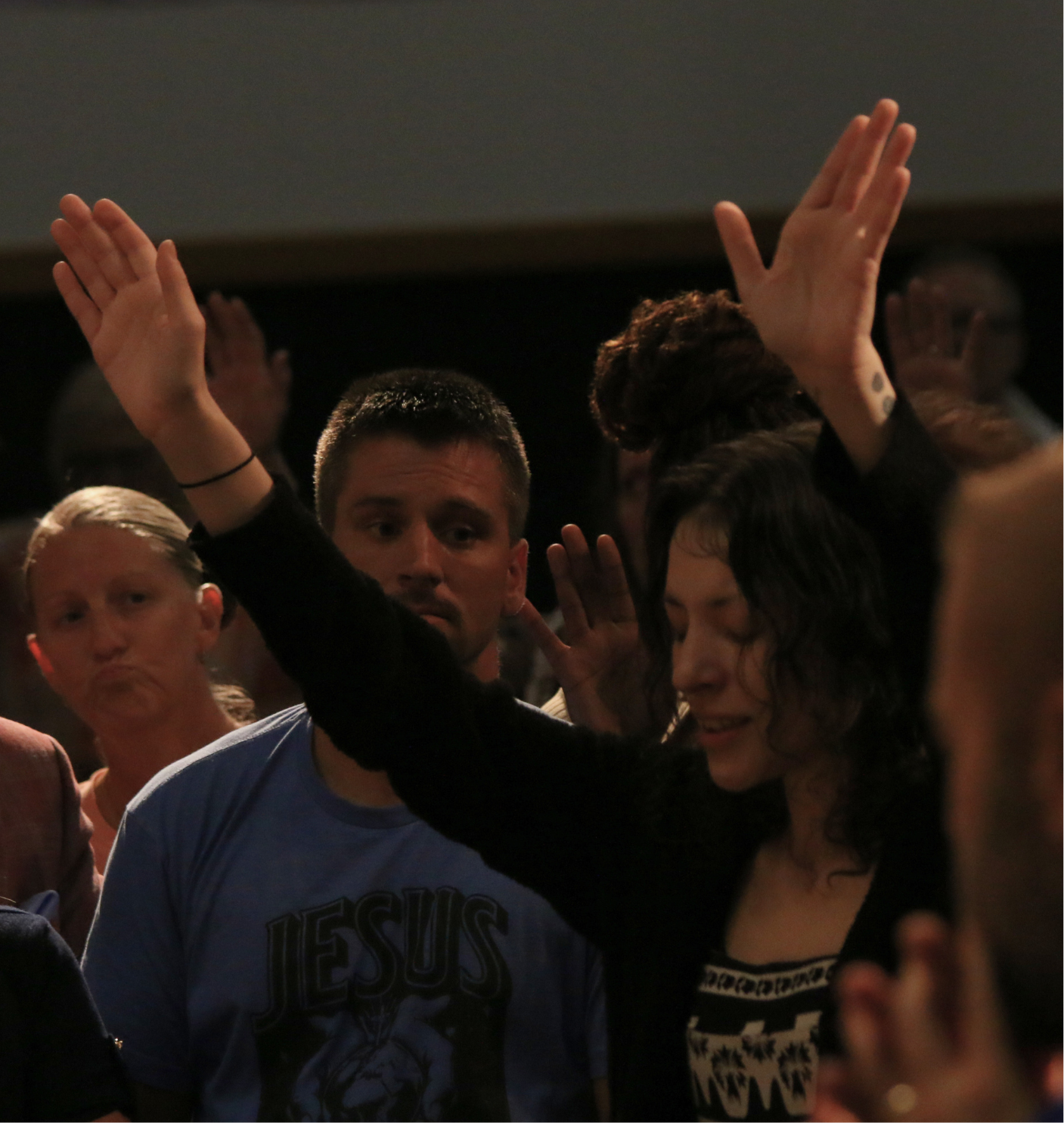 Worshippers with hands raised at a revival conference